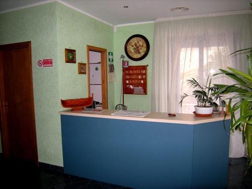 a office with a counter and a clock on the wall at Sea Garden Hotel in Acquappesa