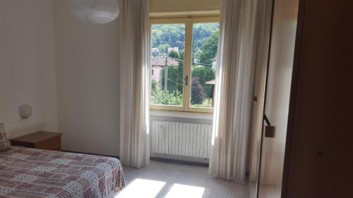 a bedroom with a bed and a large window at Civico 17 in Canzo