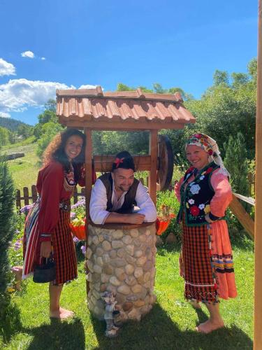 a group of three women standing next to a shrine at вила Здравец in Yagodina