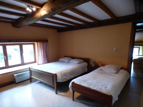 a bedroom with two beds and a large window at La Métairie in Houffalize