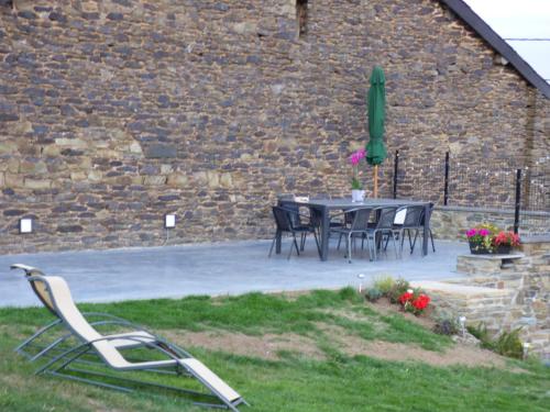 a table and chairs in front of a brick wall at La Métairie in Houffalize