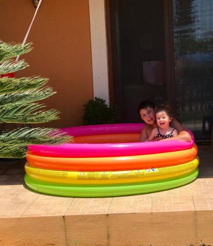 a man and a child in a inflatable pool at Boutique Hotel Ileas Village in Arkoudi