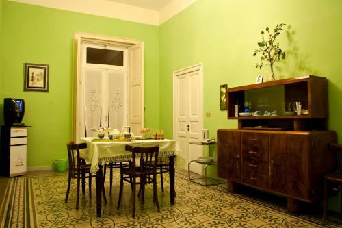 a dining room with a table and chairs and green walls at Villa Genny in Candela