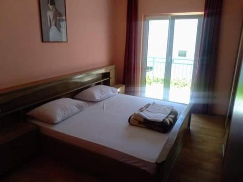 a bed in a room with a window and a bedvisor at Denis Bolanča in Primošten