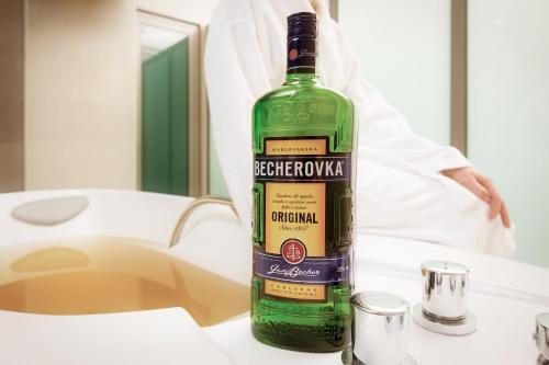 a bottle of green wine sitting on a table at Venus in Karlovy Vary