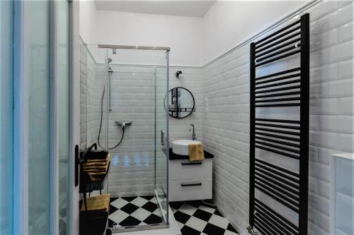 a bathroom with a glass shower and a sink at BAB-LAK Apartman in Kisvárda