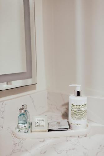 a bathroom counter with a shelf with a bottle of soap at Vinland Hotel and Lounge in Solvang