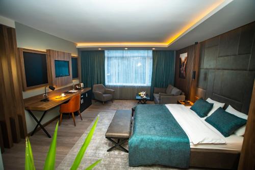 una camera d'albergo con un letto grande e una scrivania di Nova Suite Residence a Trabzon