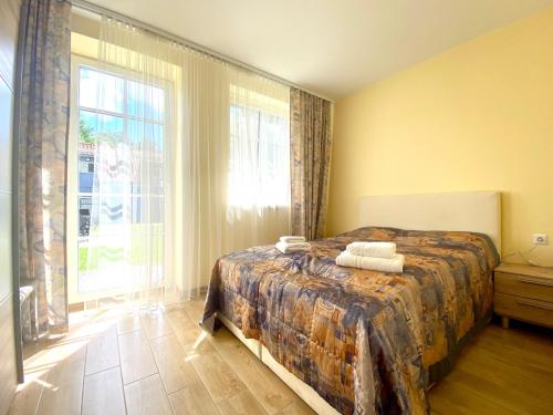 a bedroom with a bed and a large window at Karkle Seaside Apartments in Karklė