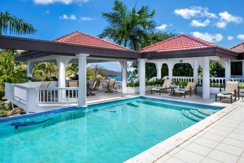 a house with a swimming pool and a gazebo at TAMAR VILLA in Virgin Gorda