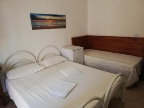 a bedroom with two beds and a picture on the wall at La Stanza Alternativa in Sannicola