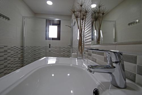 ein weißes Badezimmer mit einer Badewanne und einem Waschbecken in der Unterkunft Los fresnos de ribadesella 4 personas in Ribadesella