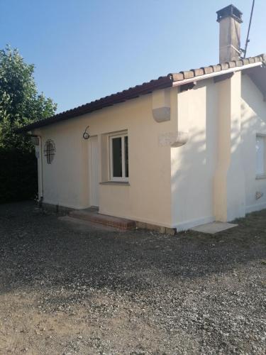 a white house with a window and a roof at La gravière in Saint-Geours-de-Maremne