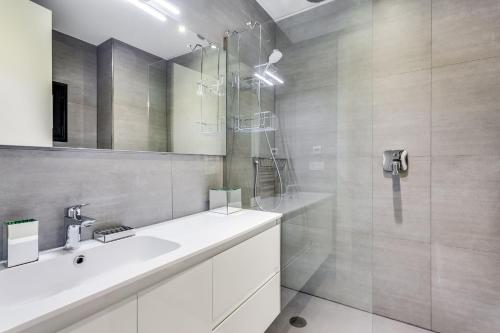 a white bathroom with a sink and a shower at by RIVA - Chic, Contemporary Studio in Puerto Banus Gardens in Marbella