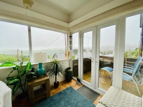 a living room with large windows and a balcony at Hendre in Blaenau-Ffestiniog