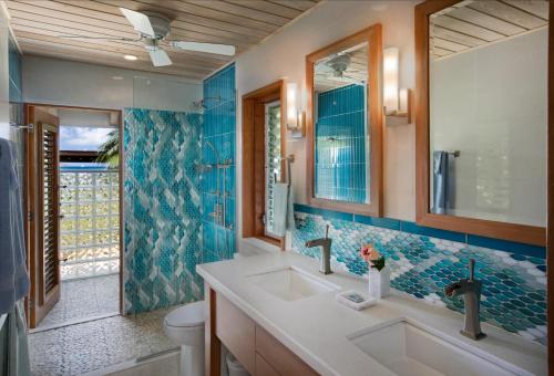 a bathroom with a sink and a toilet and blue tiles at BEACHCOMBER VILLA in Virgin Gorda