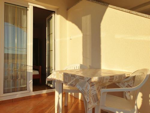 a white table and chairs on a balcony at BetaNovalja in Novalja