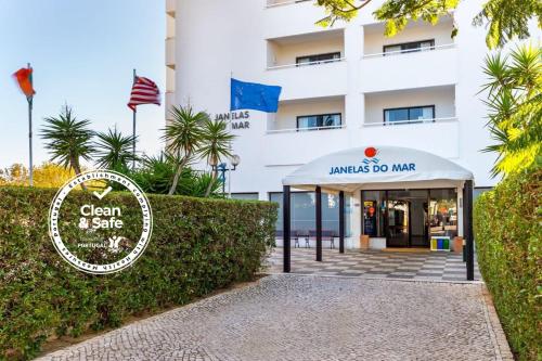 a sign in front of a building at Janelas do Mar Apartamentos Turisticos in Albufeira
