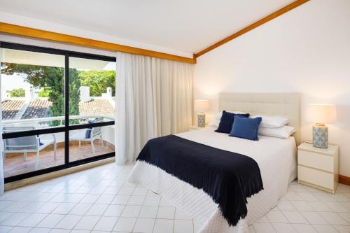 a bedroom with a large bed and a balcony at Victory Village T1 & Rooftop terrace in Quinta do Lago