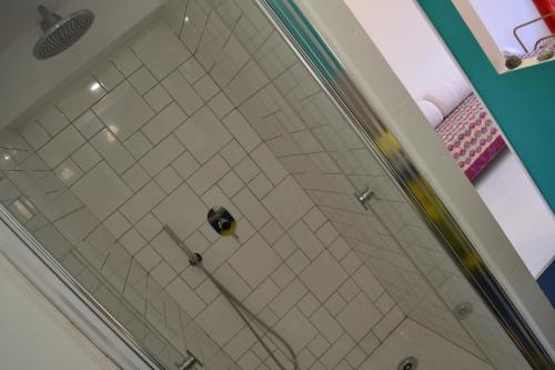 a shower in a bathroom with white tile at Chambre privative et originale, à 20 mn de Cluny in Trivy