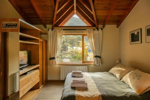 Un dormitorio con una cama grande y una ventana en Departamento Roca II - ubicacion perfecta en San Martín de los Andes