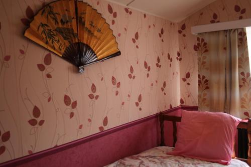 a bedroom with a bed and a flowery wallpaper at La clef de bois in Braine-le-Comte