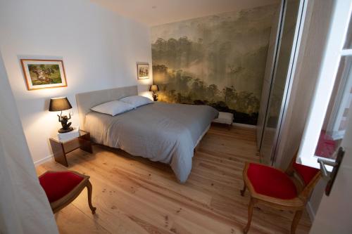 波爾多的住宿－獨特度假屋，卧室配有一张床,墙上挂有绘画作品