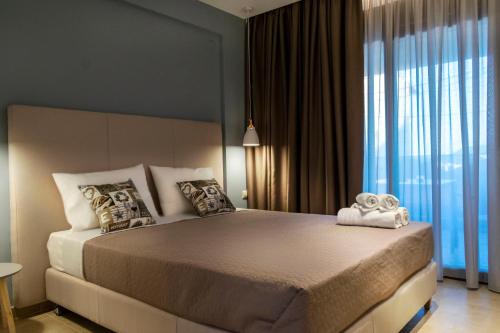 a bedroom with a large bed and a large window at Arion suites in Sarti