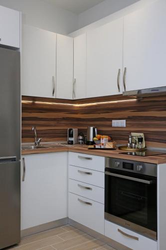 a kitchen with white cabinets and a black oven at Under the Aqueduct boutique house in Kavala