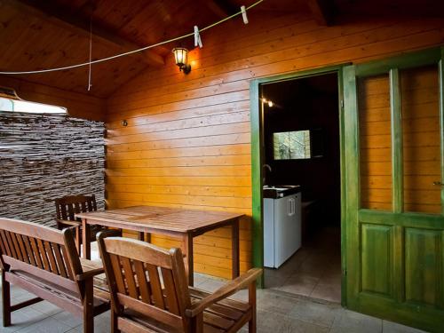 une terrasse couverte en bois avec une table et des bancs en bois dans l'établissement Bungalows Starine Tribunj, à Tribunj