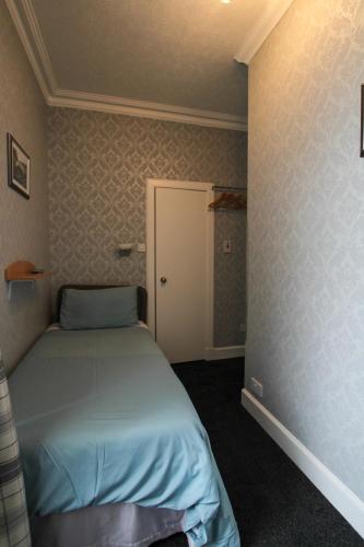 a small bedroom with a bed in a room at Dunallan Guest House in Perth