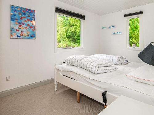 KolindにあるHoliday Home Kraghøjvejの白いベッドルーム(ベッド1台、窓2つ付)