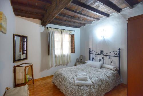 1 dormitorio con 1 cama en una habitación con ventana en Apartamentos Rurales La Vera, en Jarandilla de la Vera