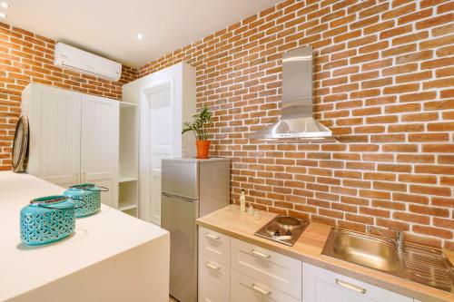 a kitchen with a brick wall and a stainless steel refrigerator at Golden Beachside terrace in Chrysi Ammoudia