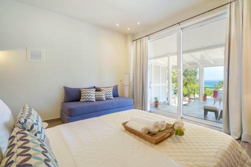 a bedroom with a bed and a blue couch at Golden Beachside terrace in Chrysi Ammoudia