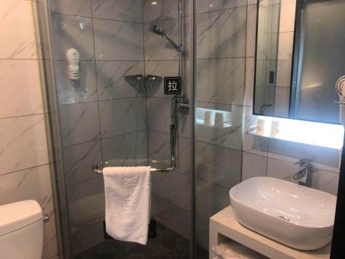 a bathroom with a shower with a toilet and a sink at 7Days Premium Anshan Railway Station Pedestrian Street Branch in Anshan