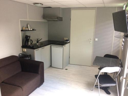 un salon avec un canapé et une table et une cuisine dans l'établissement Den Laage hof, à Heusden