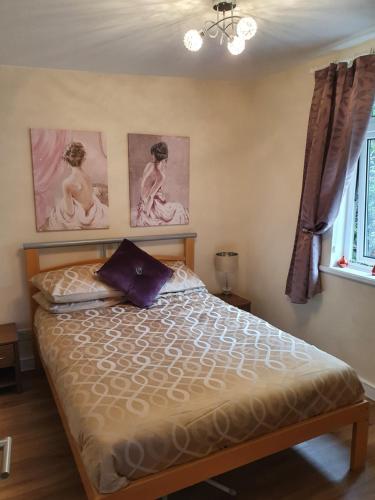 インバネスにあるNanny's little highland hooseのベッドルーム1室(壁に2枚の写真が飾られたベッド1台付)