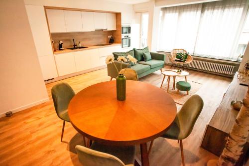 a living room with a table and a green couch at Maison Rebelle in Ostend