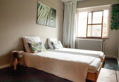 a bedroom with a bed and a window at Maison Rebelle in Ostend