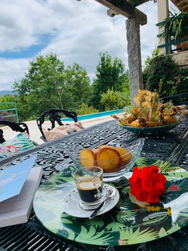 a table with a cup of coffee and a bowl of fruit at Quinta Paraíso do Ermal in Vieira do Minho
