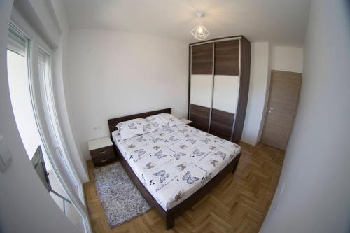 een slaapkamer met een bed in een witte kamer bij Kiniro in Trebinje