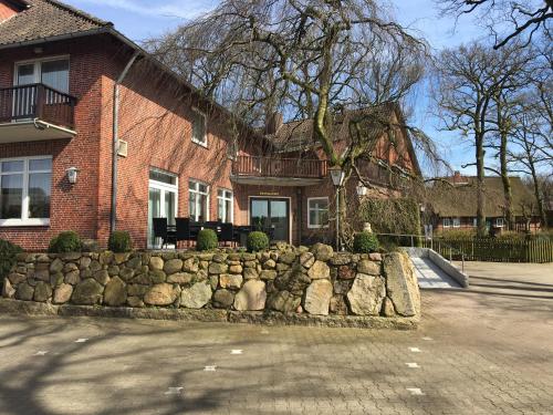 uma casa de tijolos com uma parede de pedra em frente em Studtmann's Gasthof em Egestorf