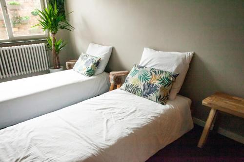 a room with two beds with pillows and a window at Maison Rebelle in Ostend