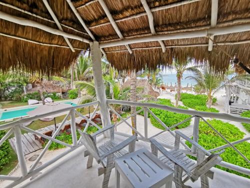 a balcony with chairs and a view of the beach at Coco Unlimited in Tulum