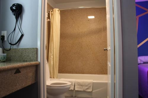 uma casa de banho com um WC, uma banheira e um chuveiro em ERTH INN by AGA Maywood em Maywood