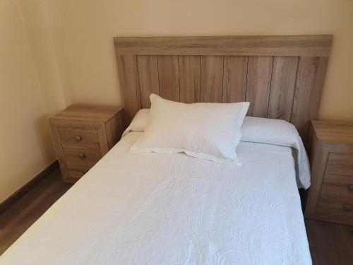 a bedroom with a white bed with two night stands at Casas Fontan in Combarro