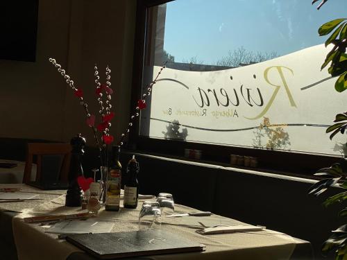 a table in a restaurant with a sign on a window at Hotel Riviera in Magnano in Riviera