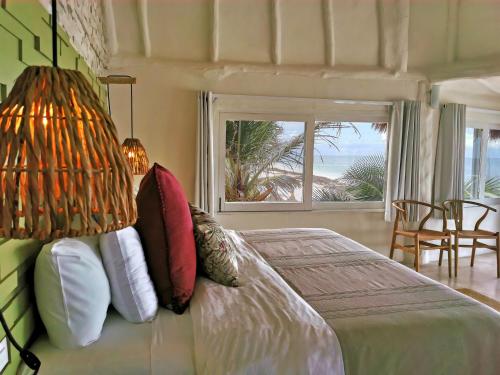 a bedroom with a bed with a view of the ocean at Coco Unlimited in Tulum