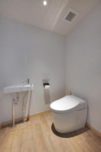 a bathroom with a white toilet and a sink at THIRD ishigakijima in Ishigaki Island